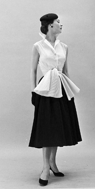1952 - Gigi is wearing a Givenchy sleeveless blouse with skirt and sash made of tiny accordian pleats, photo by Nat Farbman 