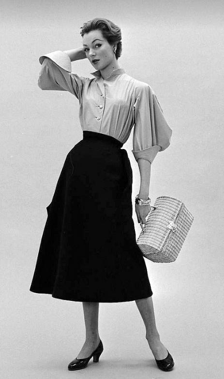 Ivy in Givenchy's skirt and blouse with wide 3/4 sleeves and exaggerated cuffs, photo by Nat Farbman, Feb. 1952