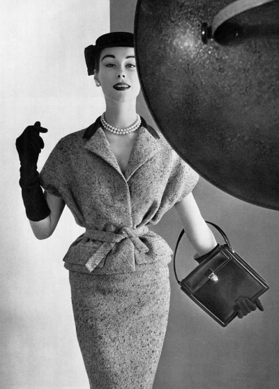 Myrtle Crawford in blue tweed two-piece with navy toile collar, the cut of the armholes evokes a chasuble, by Givenchy, photo by Pottier, 1954