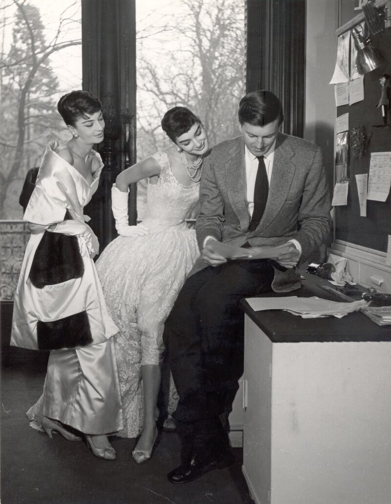Hubert de Givenchy with two of his models wearing his evening gown designs, Jacky Mazel in center, 1954